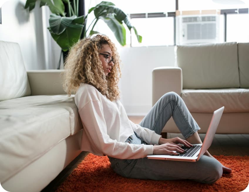 Personne travaillant sur un ordinateur portable depuis son canapé